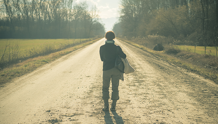 Woman standing on dirt road